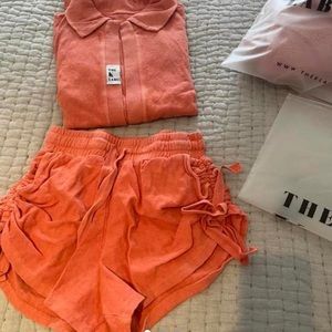 The k label orange two piece set. Labeled as size one. Can fit up to a s/m